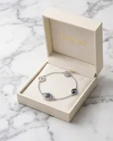 Pulsera de cadena fina con dije central en forma de ojo turco, decorado con cristales brillantes y detalles en azul. El diseño es delicado y sofisticado.