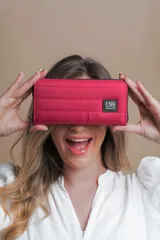 Billetera larga con cierre perimetral, confeccionada en nylon capitoneado color verde petróleo. Cuenta con correa de mano desmontable con logo estampado y parche frontal con marca LNS.