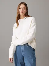 Sweater blanco de punto con cuello redondo y logo de Calvin Klein bordado en el cuello.