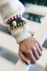 Sweater de punto color blanco crudo, confeccionado en lana merino, con diseño de flores y plantas bordadas y en relieve en tonos rosas y verdes, cuello redondo y mangas largas.