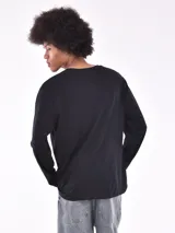 Remera blanca de manga larga, corte holgado y cuello redondo.