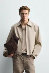 Cazadora de corte relajado confeccionada en tejido compacto de algodón. Presenta cuello solapa, cierre frontal con cremallera, mangas largas y bolsillos laterales de vivo. El bajo cuenta con acabado elástico en la espalda.