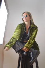 Campera verde aceituna de terciopelo con cierre frontal, cuello alto y puños elásticos.