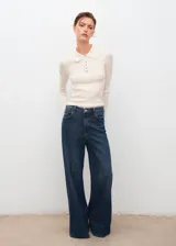 Jersey de punto fino con diseño canalé, cuello polo con cierre de botones y manga larga. Presenta un corte entallado.