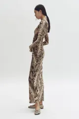 Vestido largo de malla de doble capa con estampado de piel de serpiente. Modelo entallado de manga larga, con escote redondo y detalle de costura fruncida lateral que crea un efecto drapeado.