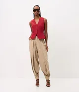 Pantalón de sastre tipo balloon color beige, con pinzas delanteras que aportan volumen, piernas amplias y bajo ajustado. Cuenta con cintura estructurada y pasacintos.
