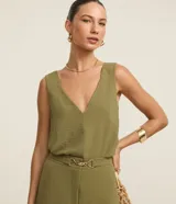 Blusa sin mangas de tejido tipo airflow, con escote en V y breteles anchos. Presenta una textura ligeramente arrugada y costura central vertical decorativa.