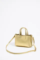 Bolso mini dorado de cuero con doble asa corta y correa fina ajustable.