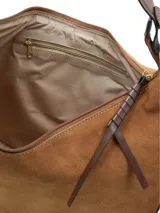 Cartera de hombro con diseño ovalado, confeccionada en cuero gamuza color camel con detalles en cuero napa. Presenta cierre en el acceso principal, logo metálico de la marca en la parte inferior y correa ajustable.