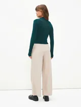 Pantalón de vestir color beige, de corte recto y tiro alto, con cierre frontal de botón y pinzas en la cintura.