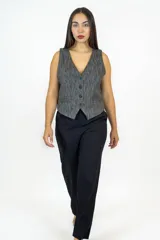 Chaleco de corte sastre en color gris con textura jaspeada, cierre frontal de botones y bolsillos laterales discretos.