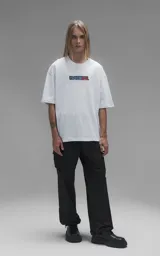 Remera blanca de corte oversize con cuello redondo y mangas cortas. Presenta un estampado central en la espalda con los personajes Goku y Goten de Dragon Ball.