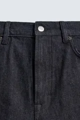 Jeans de corte slim fit en color azul oscuro, con diseño de cinco bolsillos, cierre frontal con cremallera y botón, y tejido ligeramente elástico.