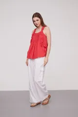 Musculosa roja de algodón con breteles finos, volados en los breteles y frunces en el frente.