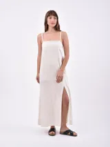 Vestido largo color crudo con breteles finos y tajo lateral.