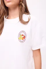 Remera blanca de algodón con cuello redondo y mangas cortas con dobladillo. Estampado pequeño en el pecho con logo de la marca y dibujo de frutas.