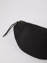 Riñonera de diseño minimalista en color verde militar, con cierre superior y tiradores de cordón negro con detalles blancos.