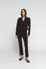 Blazer corta negra de la colección Zara Woman, con cuello solapa de muescas y manga larga. Presenta detalles de pespuntes marcados y forro interior a tono. Cierre frontal con botones.