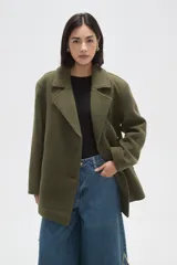 Chaqueta de corte holgado en color negro, con cuello solapa, cierre frontal con botones y bolsillos laterales.