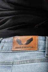 Jean oxford de tiro alto, color celeste claro, con cierre frontal y abertura en el ruedo de las piernas.