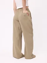 Pantalon de gabardina de corte recto y pata ancha, con cintura elástica y etiqueta decorativa en el frente.