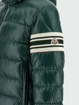 Campera puffer con capucha, color verde oscuro, con diseño acolchado horizontal y detalle de bandas blancas en la manga izquierda.
