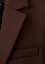 Blazer de corte recto confeccionado en lana, con cuello de solapa con muesca, cierre frontal de un botón, bolsillos laterales con solapa y bolsillo de ribete en el pecho.