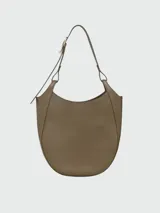 Cartera tipo hobo de gran tamaño, confeccionada en cuero con textura granulada. Presenta un diseño de silueta curva y minimalista con una correa de hombro integrada y cierre superior.