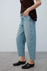Jeans de tiro medio con diseño de volumen crop, confeccionados en denim de lavado azul clásico, con cinco bolsillos y costuras decorativas laterales.