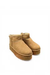 Pantubota corta de gamuza color negro, con plataforma gruesa y suela dentada. Cuenta con presilla en el talón para facilitar el calce.