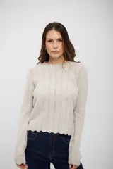 Buzo de tejido de punto en color gris claro, con diseño de textura acanalada vertical y terminaciones onduladas en cuello, puños y ruedo.