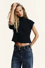 Chaleco de punto acanalado color verde brillante, con cuello alto y mangas sisa caídas.