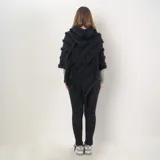 Poncho negro con flecos y detalles de textura en diagonal.