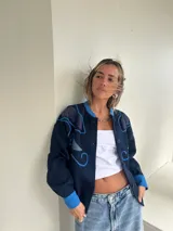 Campera azul marino con apliques de tela azul en los hombros y en el frente, con botones al frente y puños celeste.