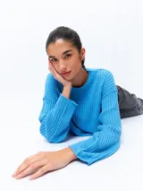 Sweater celeste de tejido de punto acanalado, corte cropped, cuello redondo y mangas largas holgadas.