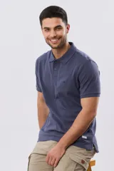 Remera polo de piqué de algodón color azul, de manga corta, con cuello camisero, cierre frontal de dos botones y pequeño logo bordado en el pecho.