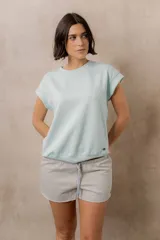 Sweater de punto color blanco, de corte relajado, con cuello redondo, manga corta japonesa de hombro caído y pretina ancha en la cintura.