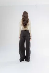 Pantalón de jean negro de corte recto y tiro alto, con detalle de botones en el dobladillo de la pierna.