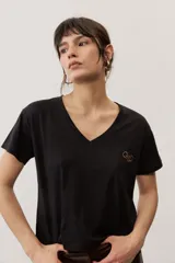 Remera de manga corta color negro, de corte clásico y escote en V, con sutil detalle bordado en el pecho.