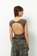 Body blanco elastizado, cavado, de manga corta, cuello bote y espalda abierta.