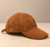 Gorro tipo visera de cuero color marrón, con ojales metálicos de ventilación y costuras pespunteadas en la visera.