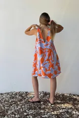 Vestido corto sin mangas con estampado abstracto en tonos naranja y celeste.