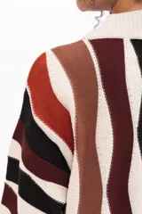 Buzo de tejido de punto con diseño de rayas verticales onduladas en tonos tierra, negro y crema. Presenta cuello redondo, mangas largas y corte holgado.