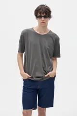 Remera de algodón lavado con cuello redondo, manga corta y corte oversize. Presenta un diseño estampado pequeño en el frente y una estampa grande en la espalda.