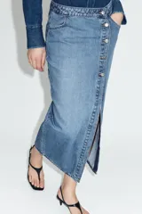 Falda midi de denim azul con diseño cruzado, cierre frontal con botones metálicos y bolsillos delanteros.