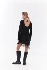 Vestido corto de algodón y lúrex color negro con hilo metálico, manga larga, cuello redondo y detalle de flecos en el ruedo.