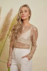 Blusa de encaje color beige con transparencias, cuello redondo y mangas largas.