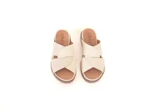 Sandalias Lota de cuero off-white, con tiras cruzadas texturizadas y suela de poliuretano color marrón con plataforma baja.
