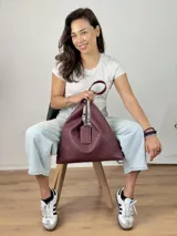 Bolso tipo hobo color borgoña, confeccionado en cuero genuino con textura granulada.