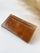 Billetera de cuero marrón, negro y beige con cierre de broche y monedero externo.